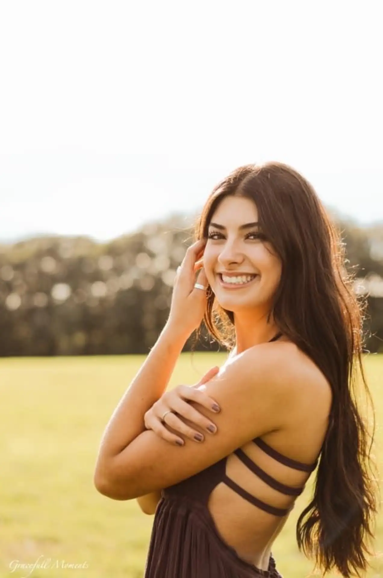 Smiling patient standing in a sunlit field