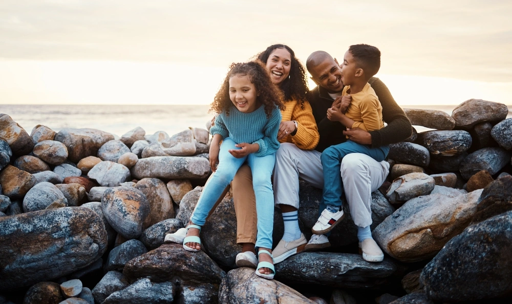 Family sitting together on coastal rocks