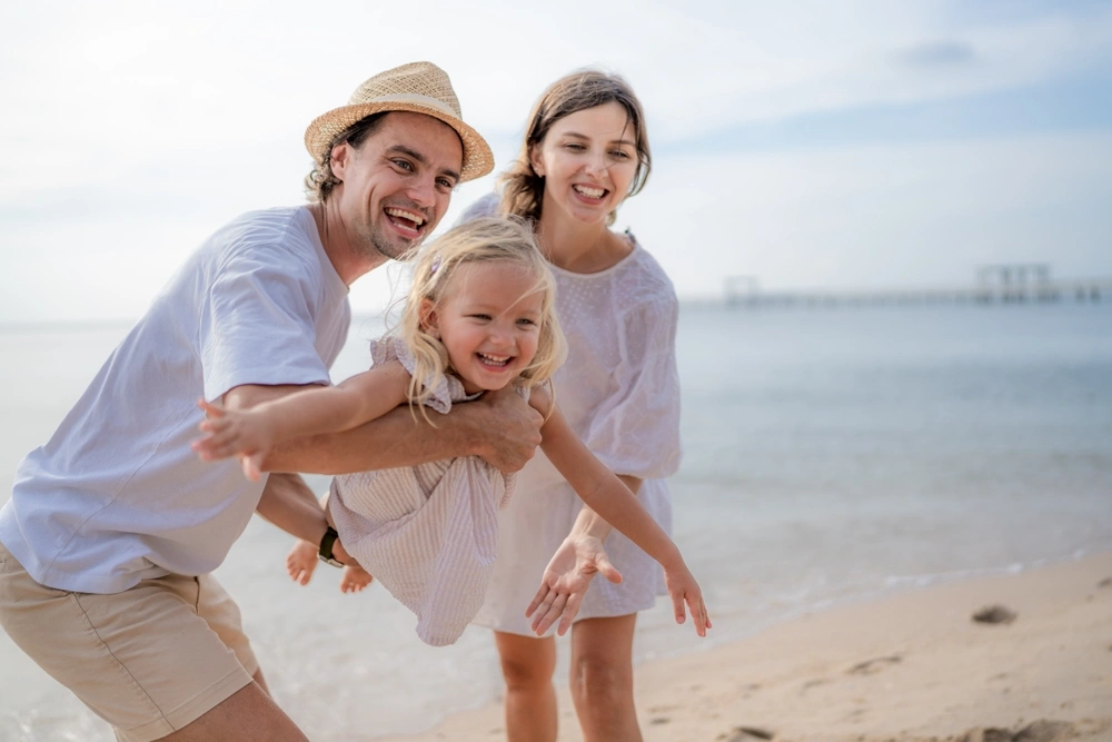 Family smiling together on the beach
